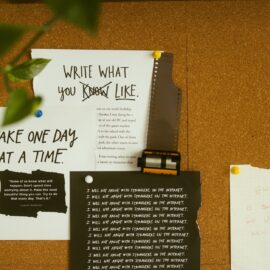 A corkboard with motivational quotes, notes, and film negatives, fostering creativity and reflection.